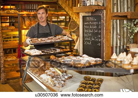 Mature man holding tray of fresh pastries View Large Photo Image Stock Photograph - Mature man holding tray of fresh pastries. Fotosearch