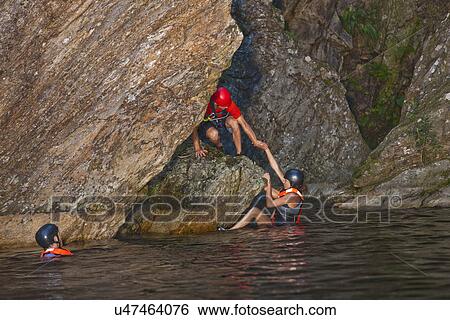 Stock Photograph - Men and woman canyoneering. Fotosearch