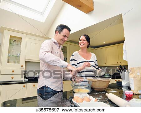 Mid adult couple baking in kitchen View Large Photo Image Stock Photo - Mid adult couple baking in kitchen. Fotosearch