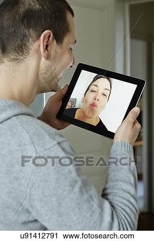 Mid adult man interacting with screen of digital tablet View Large Photo Image Stock Image - Mid adult man interacting with screen of digital tablet. Fotosearch