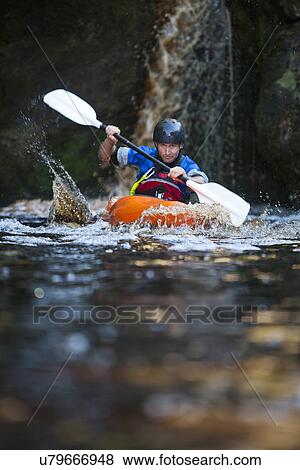 Mid adult man kayaking on river View Large Photo Image Stock Photo - Mid adult man kayaking on river. Fotosearch