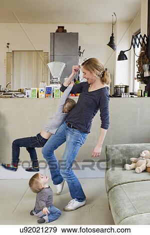 Mid adult mother playing with her two young daughters View Large Photo Image Stock Photo - Mid adult mother playing with her two young daughters. Fotosearch