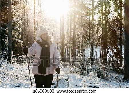 Mid adult woman nordic walking in snow covered forest View Large Photo Image Stock Photo - Mid adult woman nordic walking in snow covered forest. Fotosearch