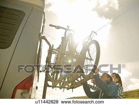 Mother and son stacking bikes on back of camper van View Large Photo Image Stock Photo - Mother and son stacking bikes on back of camper van. Fotosearch