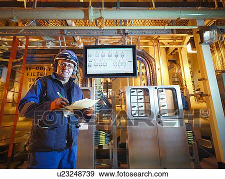 Portrait of engineer with digital display in power station View Large Photo Image Stock Photo - Portrait of engineer with digital display in power station. Fotosearch