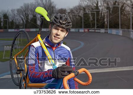 Portrait of male cyclist carrying cycle on shoulder at velodrome View Large Photo Image Stock Photograph - Portrait of male cyclist carrying cycle on shoulder at velodrome. Fotosearch