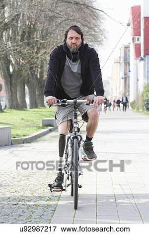 Stock Photo - Portrait of man with prosthesis leg cycling. Fotosearch