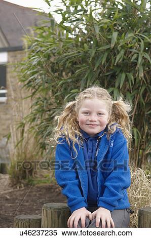 Portrait of schoolgirl sitting in garden View Large Photo Image Stock Photography - Portrait of schoolgirl sitting in garden. Fotosearch