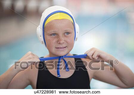 Stock Image - Portrait of schoolgirl water polo player fastening swimming cap. Fotosearch