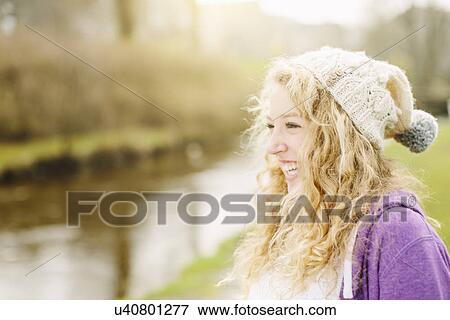 Stock Photo - Portrait of smiling teenage girl by rural river. Fotosearch