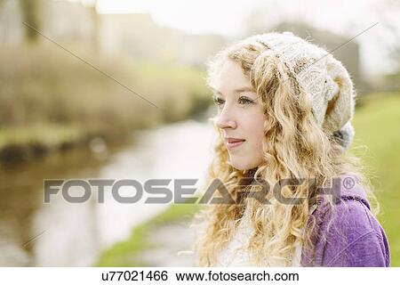 Stock Photograph - Portrait of teenage girl by rural river. Fotosearch