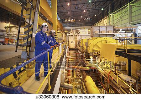 Stock Photo - Portrait of workers in turbine hall of power station. Fotosearch