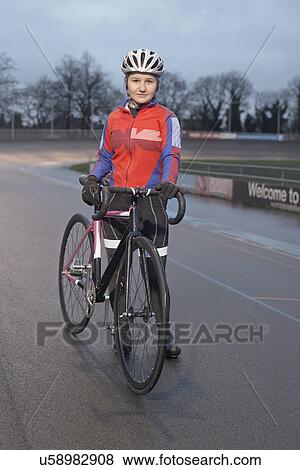 Portrait of young female cyclist with cycle at velodrome View Large Photo Image Stock Photo - Portrait of young female cyclist with cycle at velodrome. Fotosearch