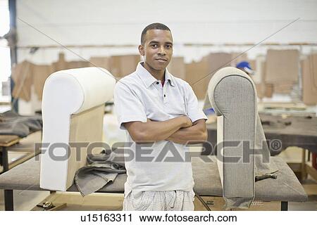 Stock Image - Portrait of young male upholsterer in workshop. Fotosearch