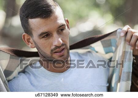 Portrait of young man putting on jacket View Large Photo Image Stock Photo - Portrait of young man putting on jacket. Fotosearch