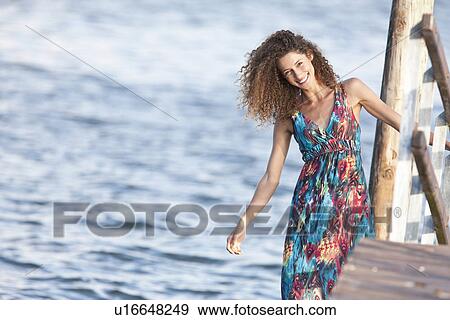 Stock Photo - Portrait of young woman on jetty. Fotosearch