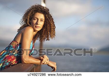 Stock Photograph - Portrait of young woman on jetty. Fotosearch