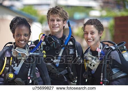 Stock Photo - Portrait three young adult scuba divers. Fotosearch