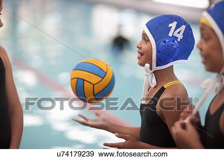 Schoolgirl water polo players poolside with ball View Large Photo Image Stock Photo - Schoolgirl water polo players poolside with ball. Fotosearch