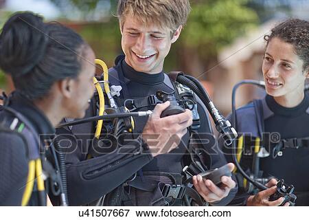 Scuba diving instructor demonstrating oxygen mask to female pupils View Large Photo Image Stock Photo - Scuba diving instructor demonstrating oxygen mask to female pupils. Fotosearch