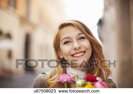Smiling young woman with a bunch of flowers View Large Photo Image Stock Image - Smiling young woman with a bunch of flowers. Fotosearch