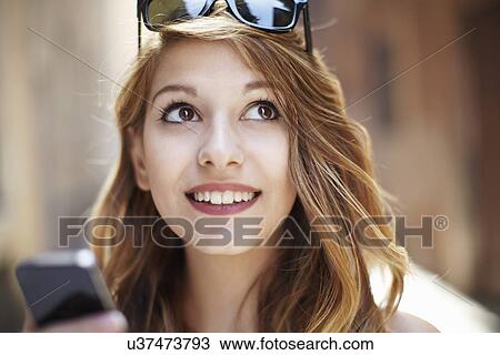 Sophisticated young woman looking up on street View Large Photo Image Stock Image - Sophisticated young woman looking up on street. Fotosearch