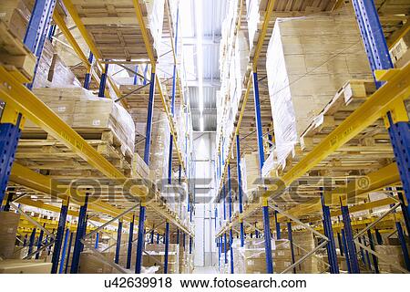 Stock Photo - Stacked shelves in distribution warehouse. Fotosearch