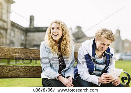 Teenage brother and sister sitting on bench View Large Photo Image Stock Photo - Teenage brother and sister sitting on bench. Fotosearch