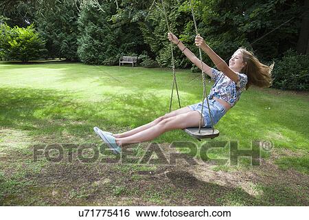 Teenage girl on swing View Large Photo Image Stock Photograph - Teenage girl on swing. Fotosearch