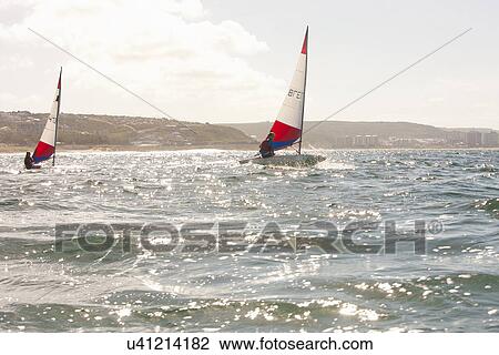 Stock Image - Teenager sailing boat. Fotosearch
