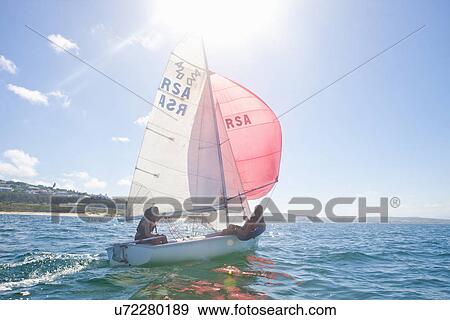 Stock Photo - Teenager sailing boat. Fotosearch