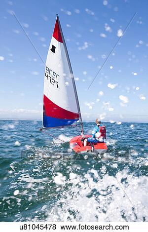 Stock Photo - Teenager sailing boat. Fotosearch