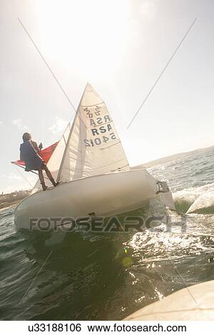 Stock Photograph - Teenager sailing boat. Fotosearch