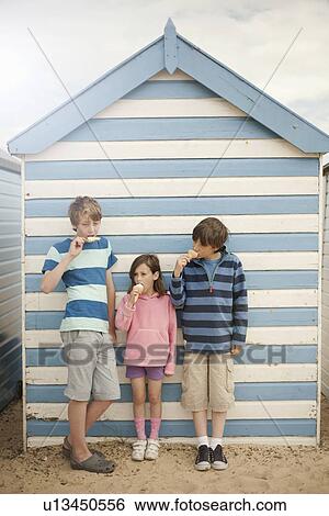 Three children eating ice cream cones, Southwold, Sussex, UK View Large Photo Image Stock Photograph - Three children eating ice cream cones, Southwold, Sussex, UK. Fotosearch
