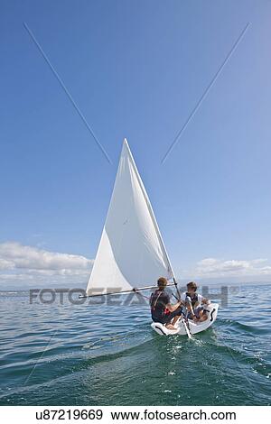 Two young men sailing out to sea View Large Photo Image Stock Photo - Two young men sailing out to sea. Fotosearch