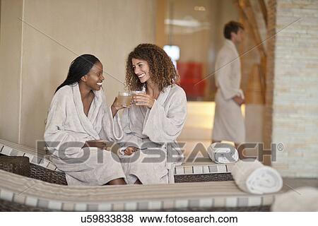 Two young women chatting on loungers in spa View Large Photo Image Stock Photo - Two young women chatting on loungers in spa. Fotosearch