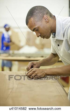 Upholsterer attaching textile to furniture View Large Photo Image Stock Image - Upholsterer attaching textile to furniture. Fotosearch