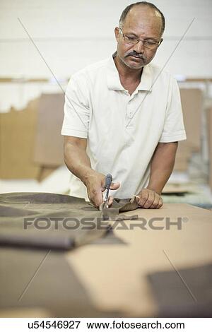 Upholsterer cutting leather with scissors View Large Photo Image Stock Photo - Upholsterer cutting leather with scissors. Fotosearch
