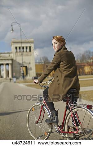 Woman cycling, monument in background, Munich, Germany View Large Photo Image Stock Image - Woman cycling, monument in background, Munich, Germany. Fotosearch