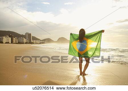 Woman holding Brazilian flag on Copacabana Beach, Rio, Brazil View Large Photo Image Picture - Woman holding Brazilian flag on Copacabana Beach, Rio, Brazil. Fotosearch