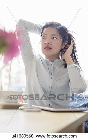 Stock Photo - Woman putting up her hair. Fotosearch