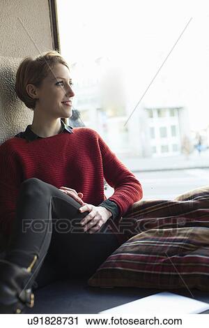Woman sitting by window View Large Photo Image Stock Image - Woman sitting by window. Fotosearch