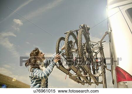 Woman stacking bikes on back of camper van View Large Photo Image Stock Photography - Woman stacking bikes on back of camper van. Fotosearch