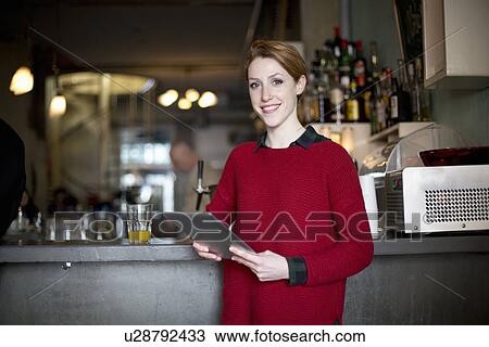 Woman using digital tablet by bar View Large Photo Image Stock Image - Woman using digital tablet by bar. Fotosearch