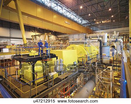 Stock Photography - Workers in turbine hall of power station. Fotosearch