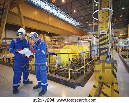 Workers reading notes in turbine hall of power station View Large Photo Image Picture - Workers reading notes in turbine hall of power station. Fotosearch