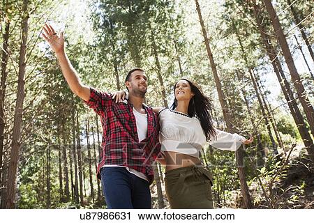 Young couple fooling around in forest, arms outstretched View Large Photo Image Stock Image - Young couple fooling around in forest, arms outstretched. Fotosearch