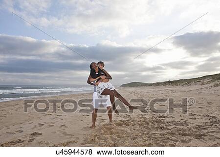 Young couple fooling around on beach View Large Photo Image Stock Photo - Young couple fooling around on beach. Fotosearch