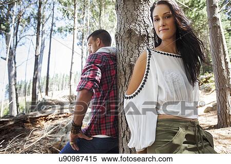 Young couple leaning against tree in forest View Large Photo Image Stock Photography - Young couple leaning against tree in forest. Fotosearch