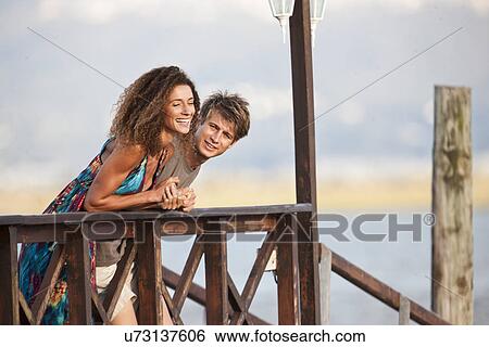 Young couple on jetty View Large Photo Image Stock Photograph - Young couple on jetty. Fotosearch